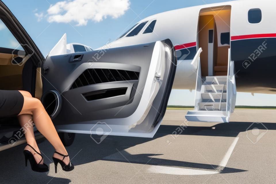 부유 한 여성이 개인 비행기의 앞에 주차 된 차의 스테핑의 낮은 섹션