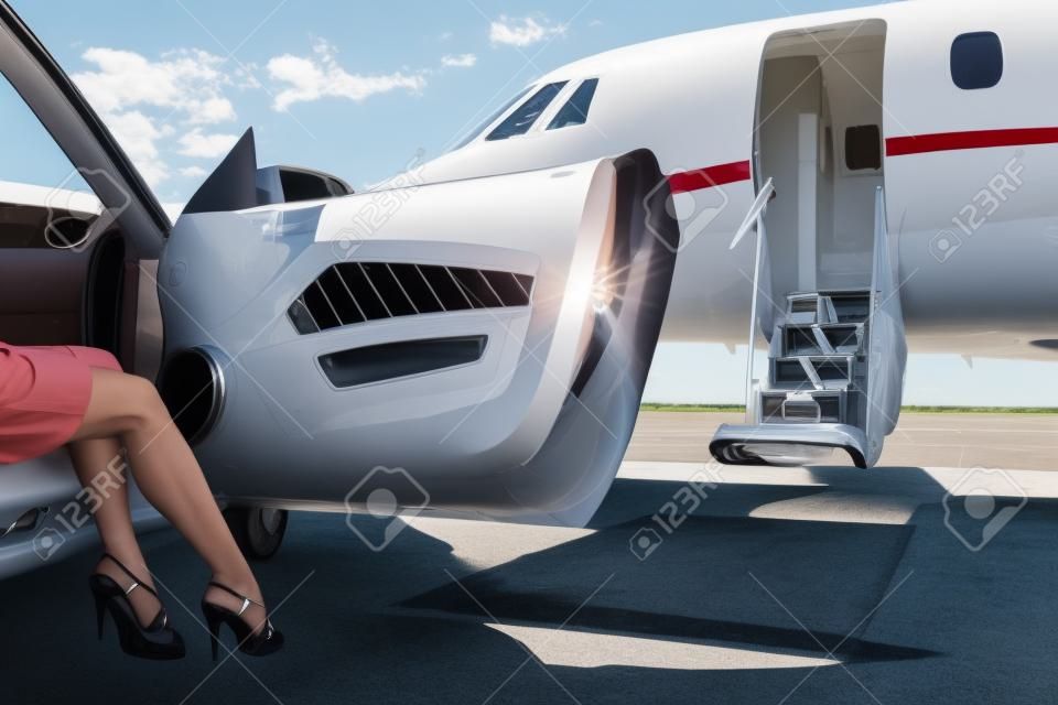 Lage sectie van rijke vrouw stapt uit de auto geparkeerd voor prive-vliegtuig