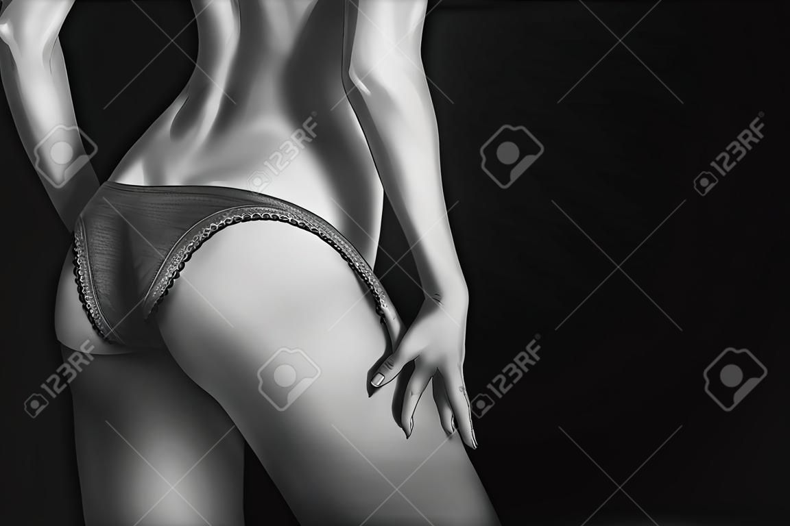 déshabiller culotte de tan corps féminin mince sur fond noir avec fond, monochrome