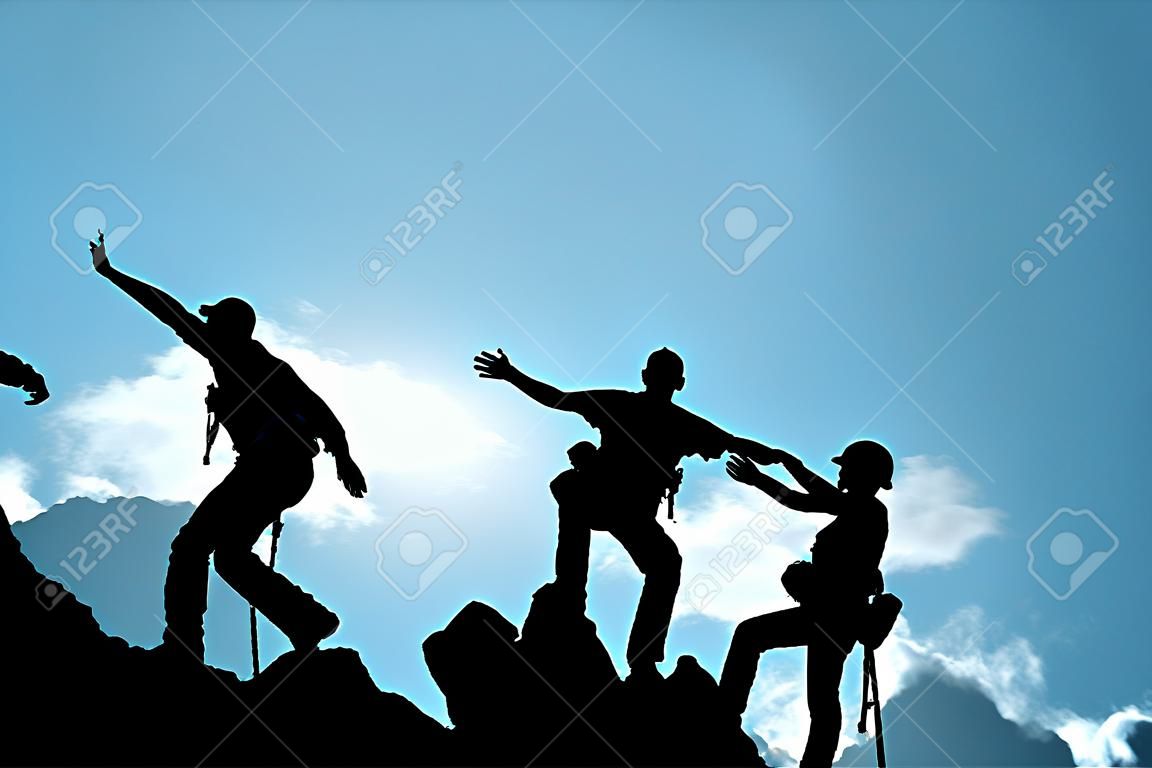Az emberek csoportja hegyi hegymászáson segítik a csapatmunkát, a siker koncepcióját