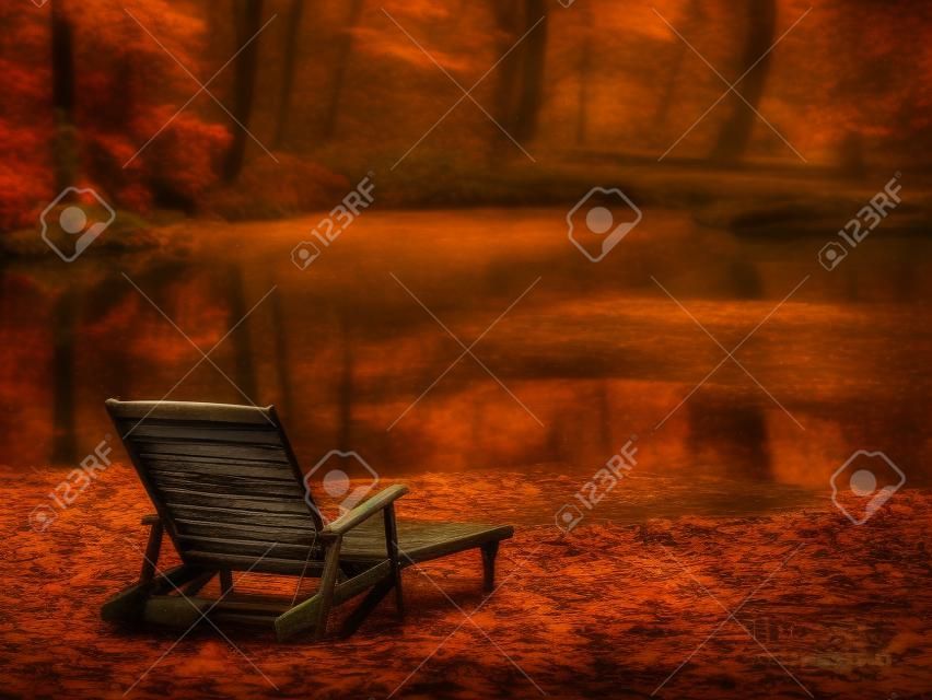 old wooden deck chair on a pond shore in a moody autumn rainy day