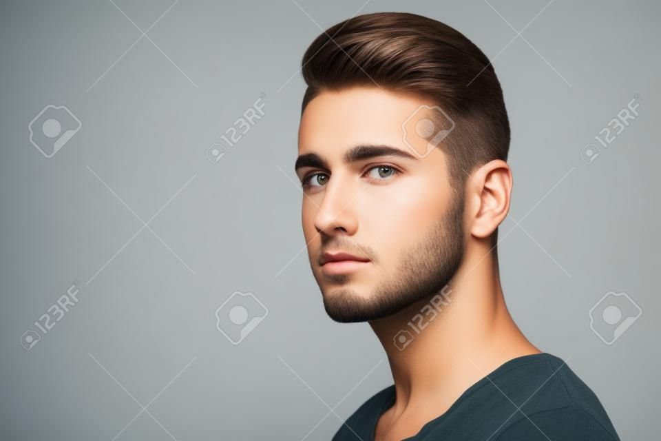 Oldalnézetből egy jóképű fiatalember arc portré elszigetelt fehér alapon