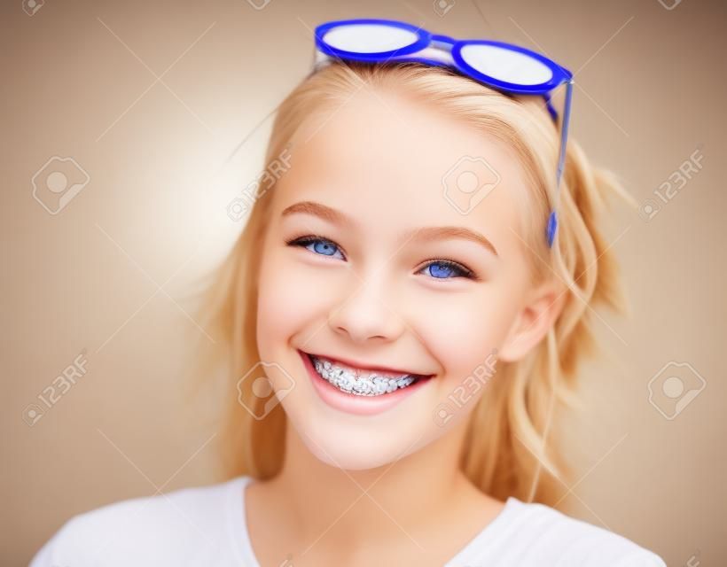 bella ragazza teenager bionda con le parentesi graffe sui suoi denti che sorride