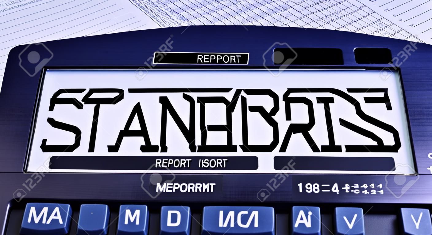 Uma calculadora rotulada STANDARDS está na mesa perto do relatório. Conceito financeiro