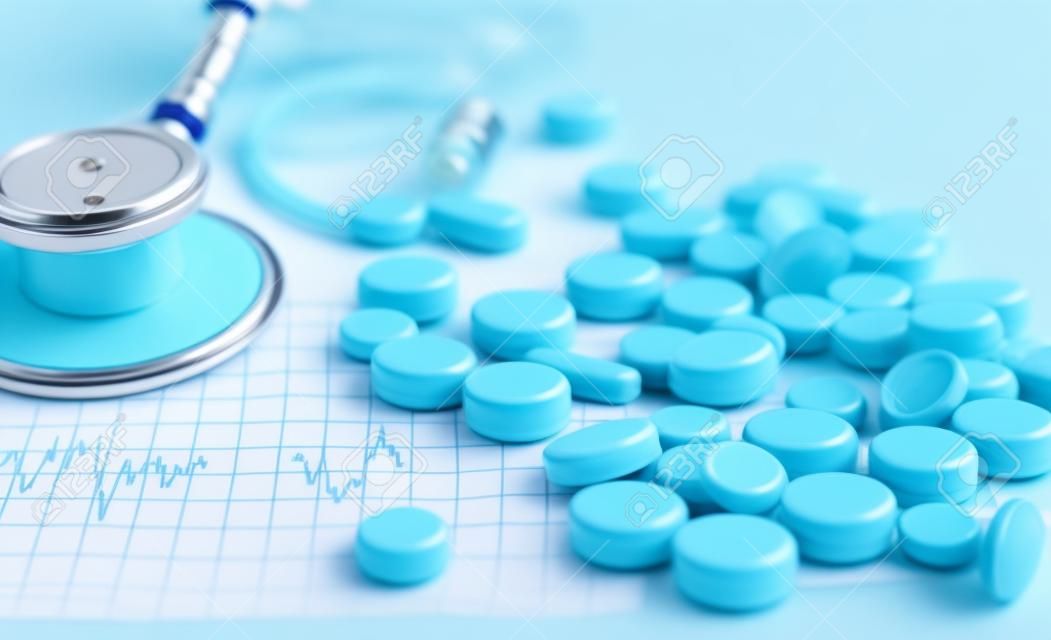 stetoscopio, pillole, fiale in sala medica su sfondo blu vista dall'alto mockup