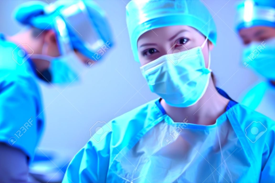 Хирург команды при работе в операционной комнате