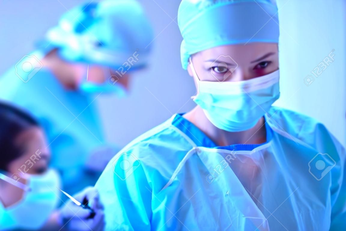 Хирург команды при работе в операционной комнате