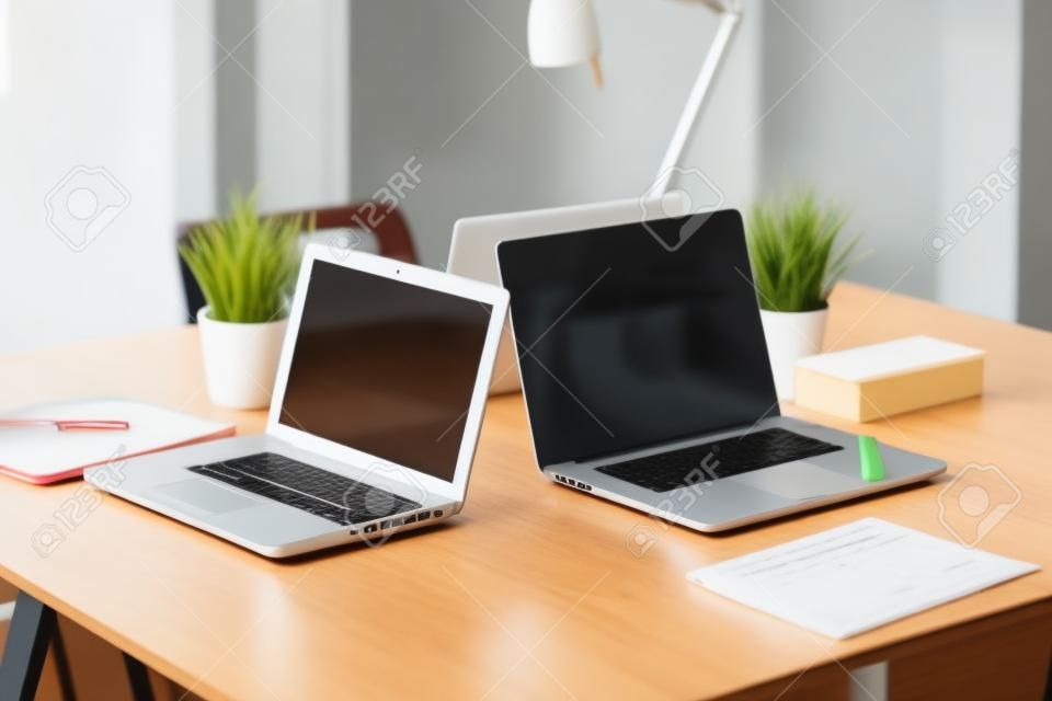 Young woman sitting at office table with laptop. Young woman. Laptop