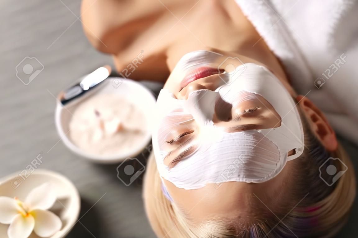 Mascarilla Hermosa joven en el spa, mujer esteticista aplicando máscara facial
