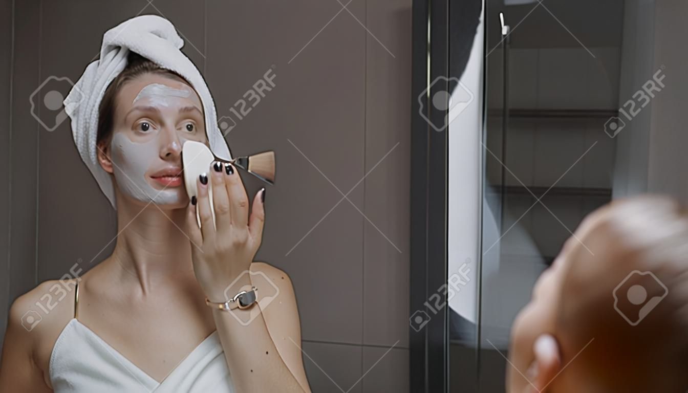 Daily beauty treatment - woman applying clay mask