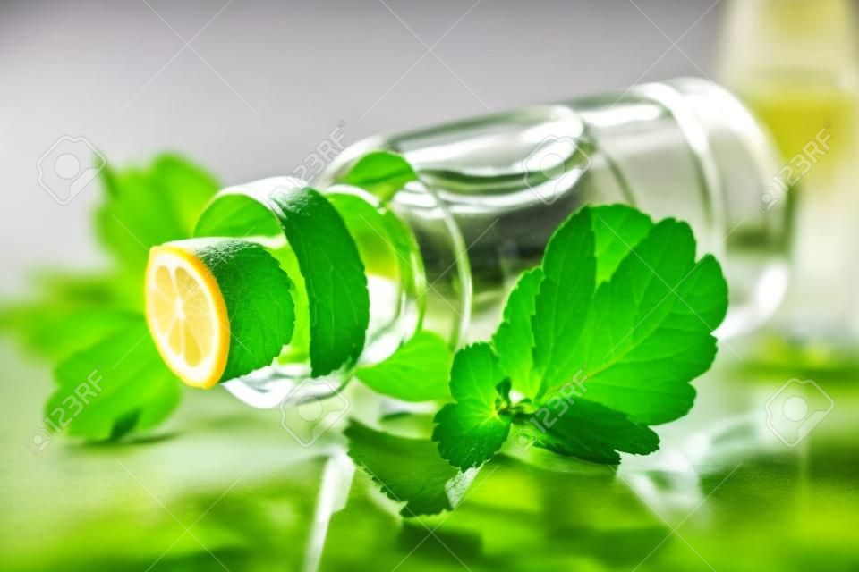 Aromatic oils Lemon balm in a glass bottle with fresh leaves macro horizontal 
