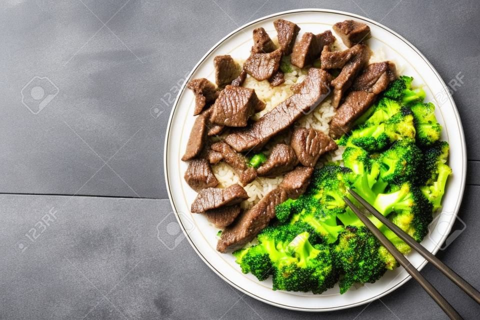 Rindfleisch mit Brokkoli und Reis auf einen Teller auf dem Tisch. horizontale Ansicht von oben