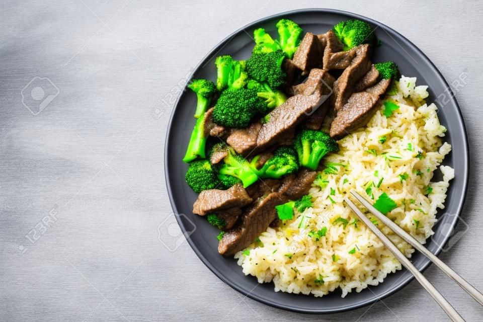 Rindfleisch mit Brokkoli und Reis auf einen Teller auf dem Tisch. horizontale Ansicht von oben