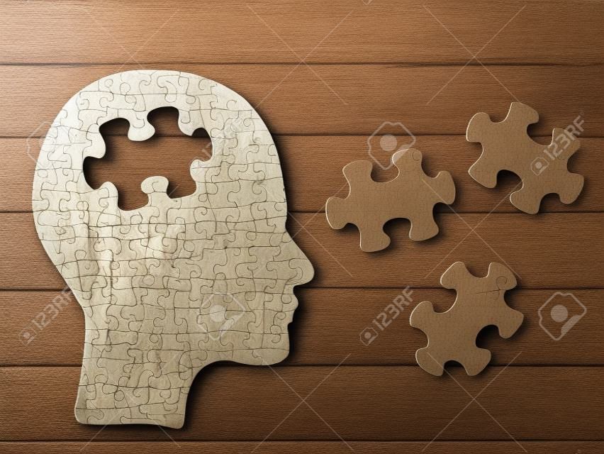 Puzzle cervello concetto testa. Profilo di testa umana fatta da carta marrone con un pezzo di puzzle tagliato fuori. Scegli la tua personalità che si adatta