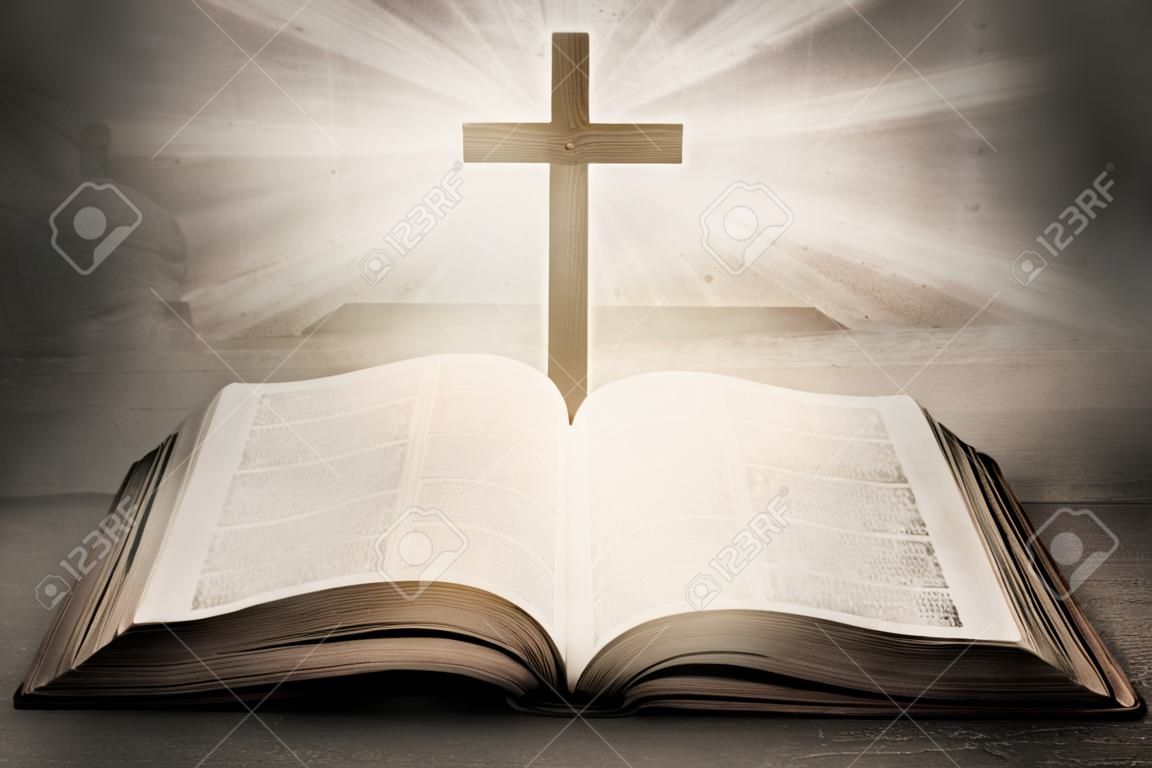 Открытая Библия с деревянным крестом в середине. Христианская концепция