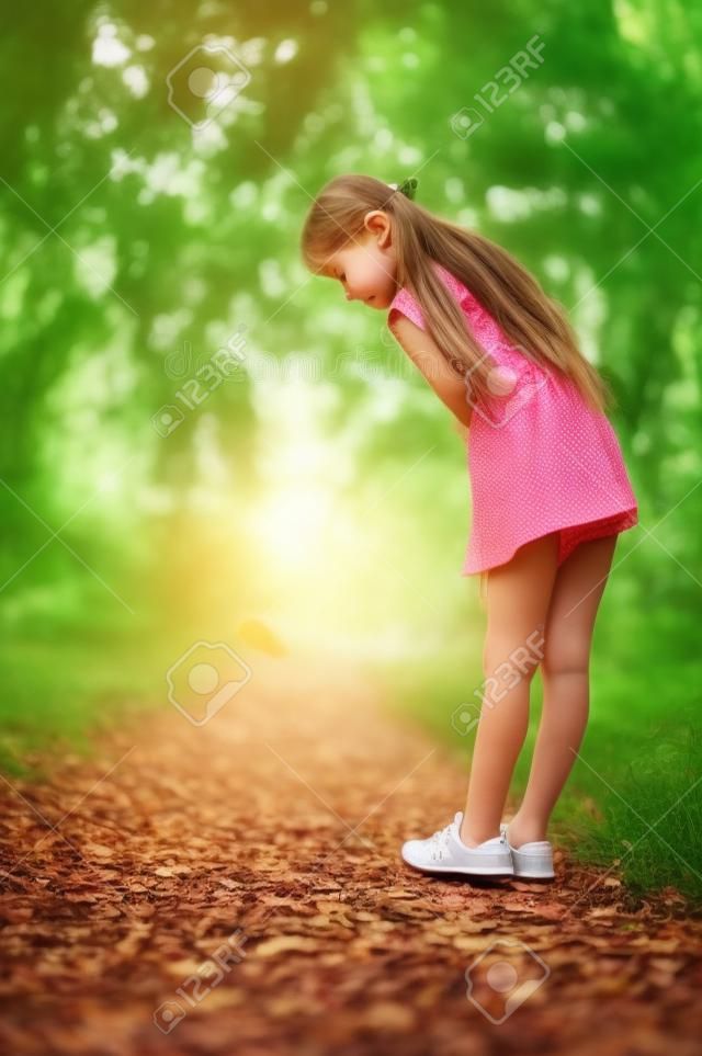 Niña camina por el bosque. Niña paseando por el parque.Una niña de 9 años salió a pasear por la calle en verano o principios de otoño. Colegiala caminando después de la escuela. Niña, con, pelo largo, en, un, vestido