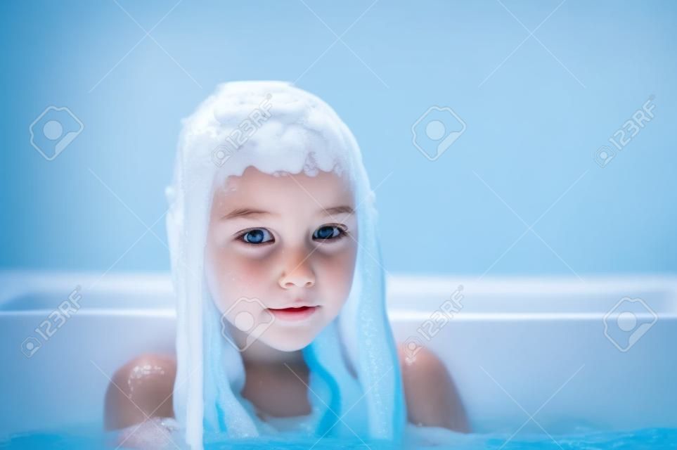 Ragazza all'interno del bagno. Una bambina si bagna in una vasca da bagno con schiuma. Una bambina di 9 anni fa il bagno. Concetto di purezza