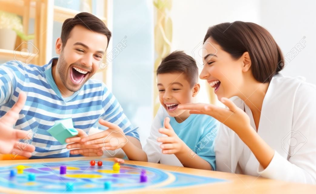 Famiglia felice che gioca gioco da tavolo a casa, concetto di felicità