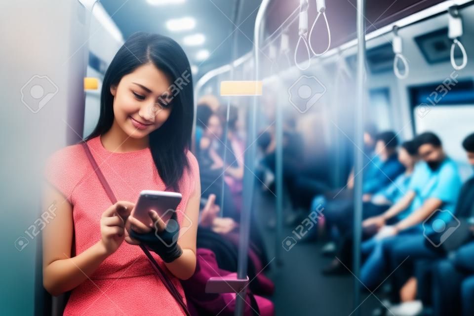 Frau, die Mobiltelefon innerhalb des Zugabteils verwendet