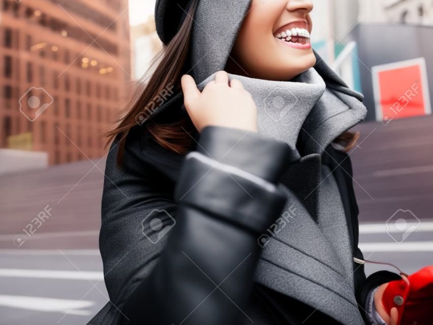 Close-up portrait, stylish young woman with invisible braces, girl in jacket smiling on the street
