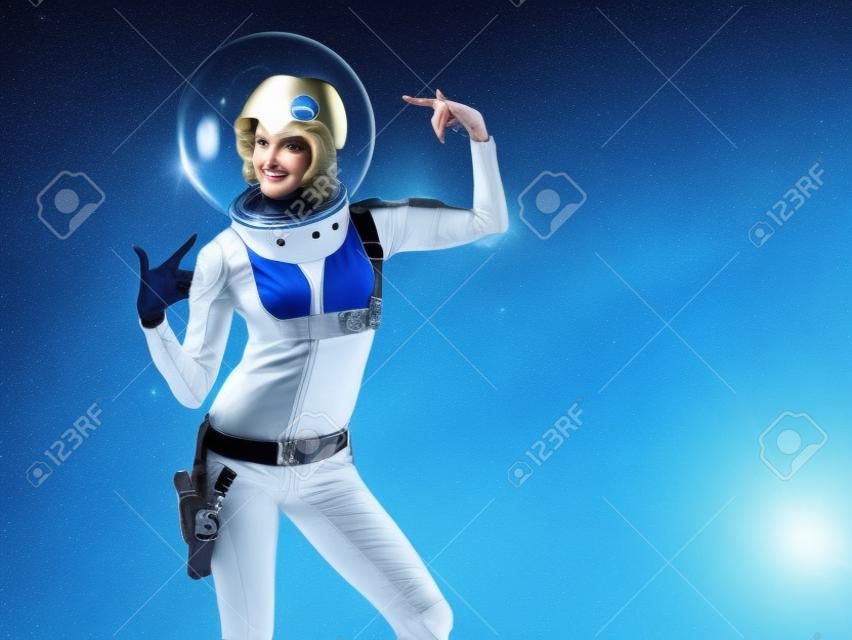 Fantástico disfraz de astronauta al estilo retrofuturista. una joven rubia hermosa con un traje azul y un casco esférico. pionero de la exploración espacial, era atómica, estilo retro