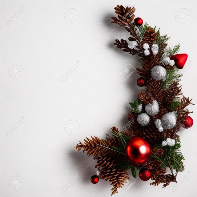 widok z góry na świąteczne gałęzie jodły, bombki i szyszki, na białym tle