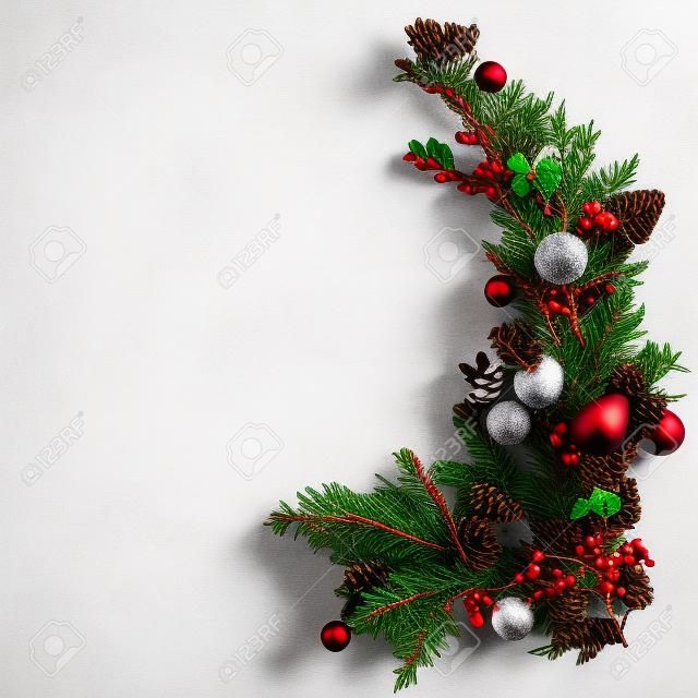 widok z góry na świąteczne gałęzie jodły, bombki i szyszki, na białym tle