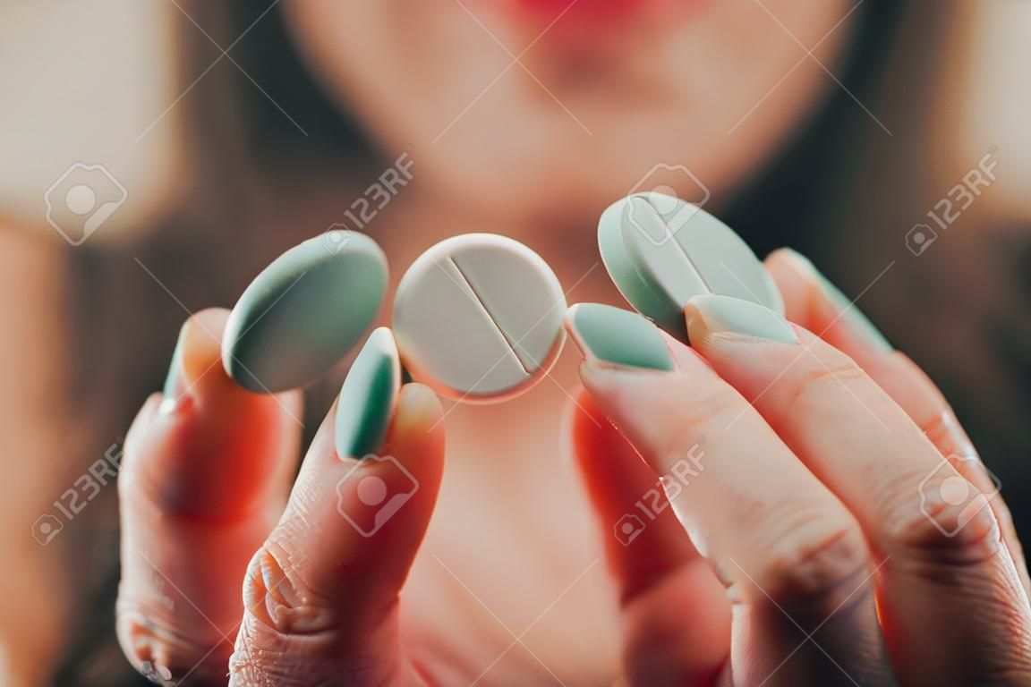 mujer que muestra la píldora en la mano