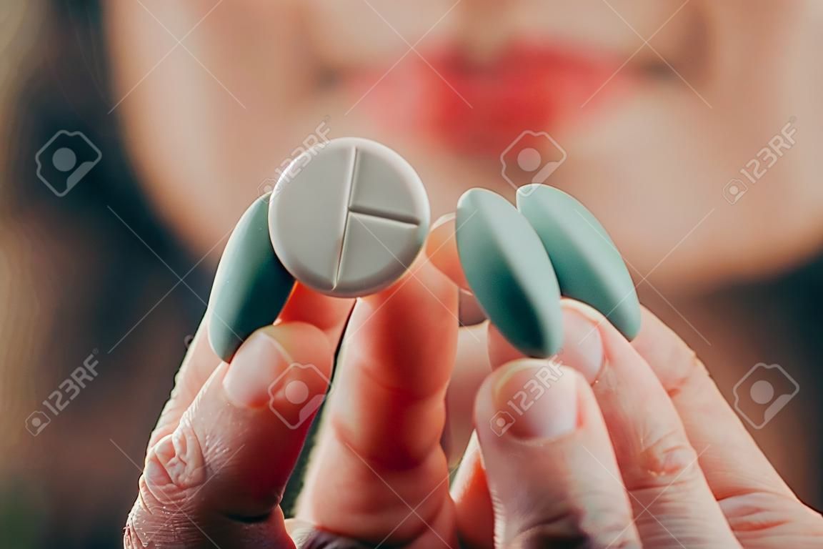 Frau zeigt Pille in der Hand