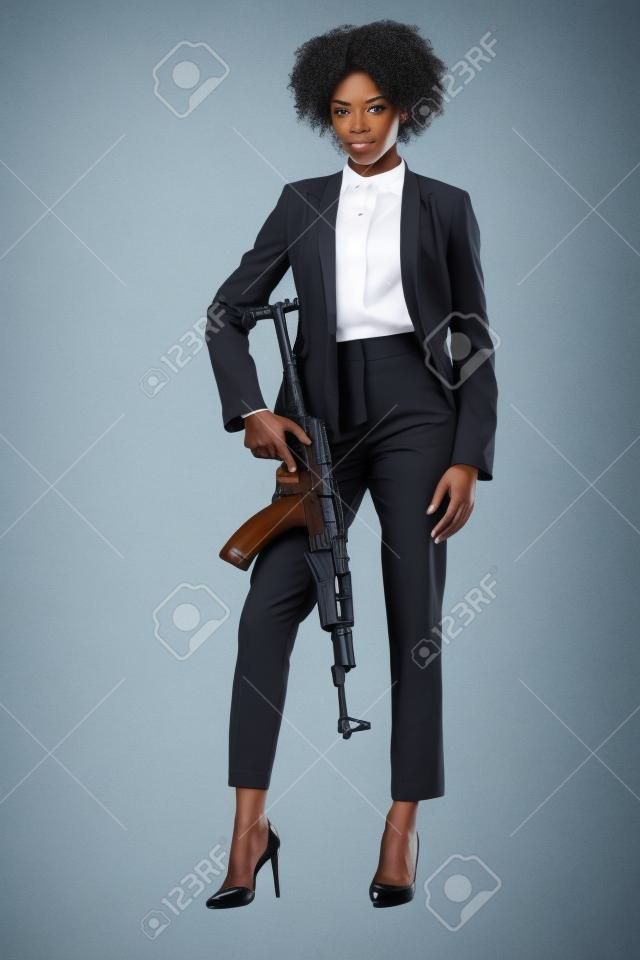 african american female spy in suit with rifle, isolated on white