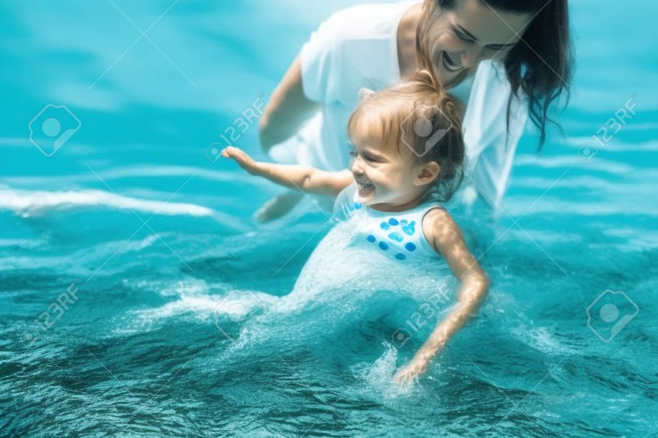 felice madre e figlia che nuotano insieme nel fiume