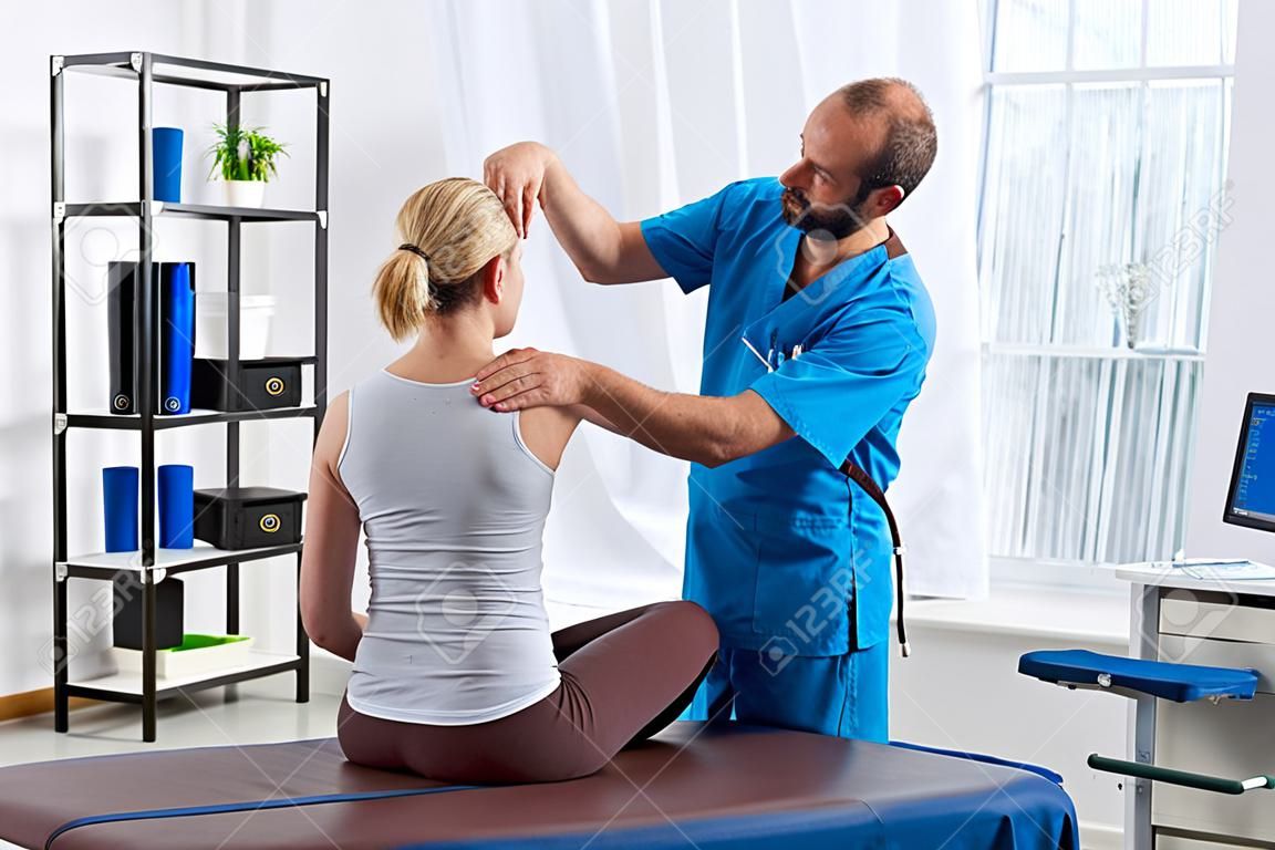 Physiotherapist doing massage to woman on massage table in hospital
