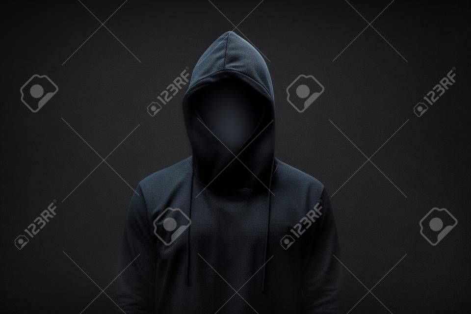 homem sem rosto em hoodie em pé isolado no preto