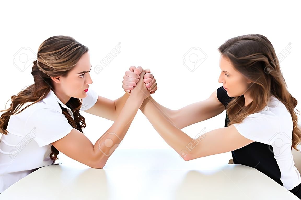 side view of angry twins armwrestling at table isolated on white