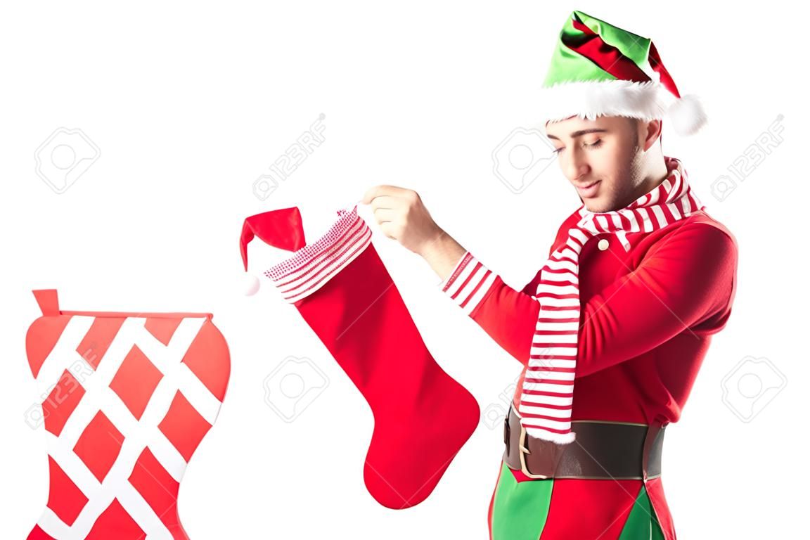 man in kerst elf kostuum putting cadeau in rood kerst kousen geïsoleerd op wit