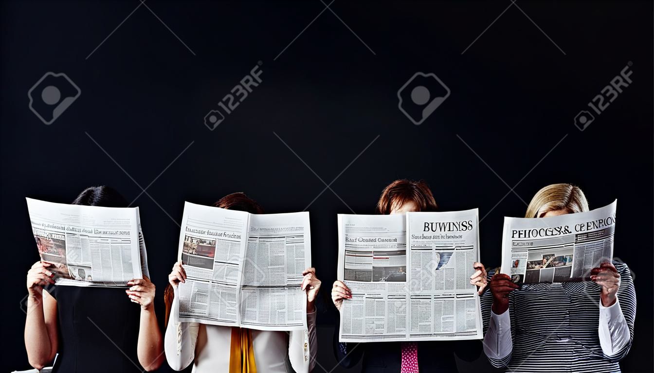 gruppo di uomini d'affari casuali con facce oscure che leggono giornali aziendali isolati su nero
