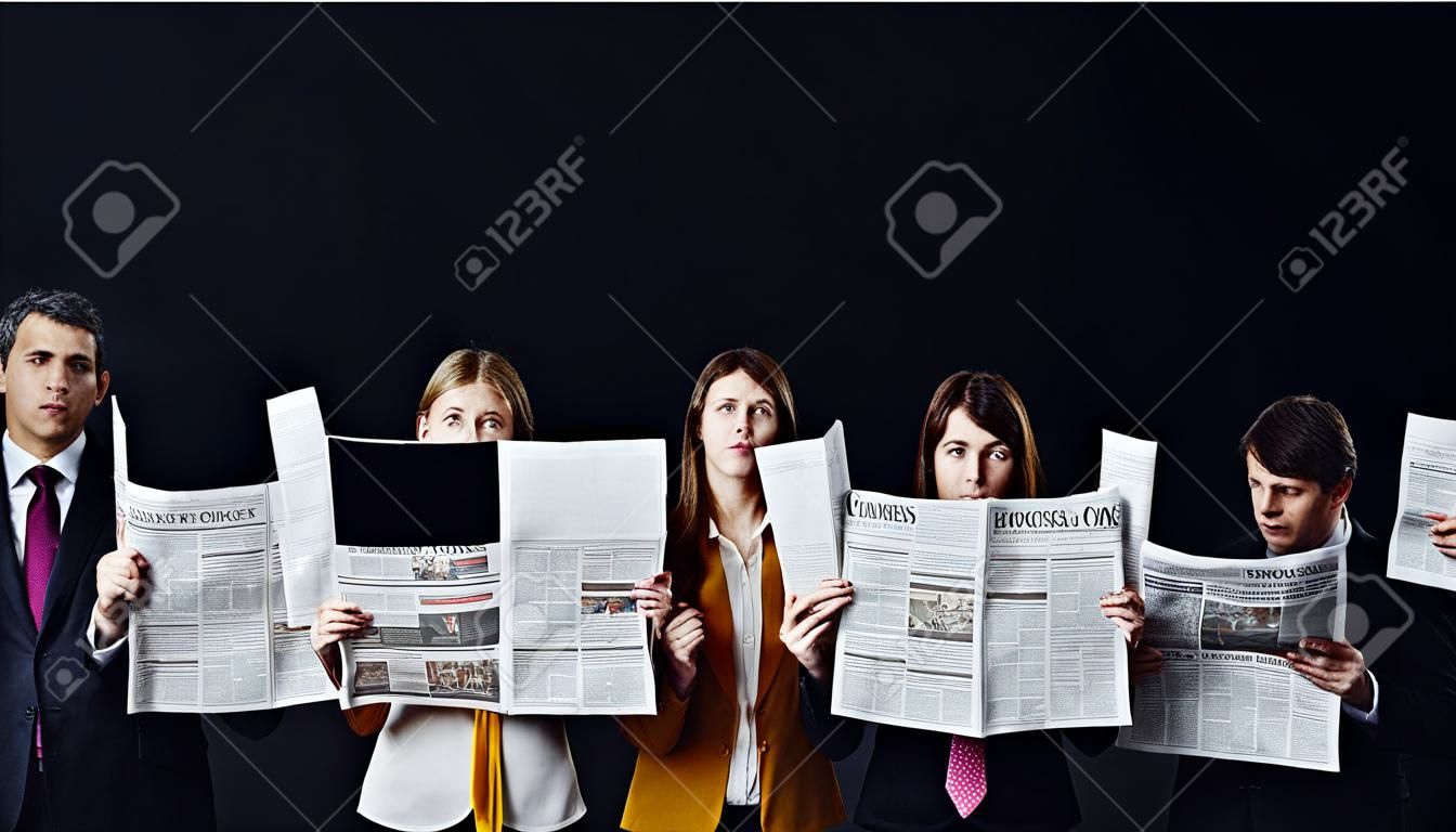 Gruppe von Gelegenheitsgeschäftsleuten mit obskuren Gesichtern, die Geschäftszeitungen einzeln auf Schwarz lesen
