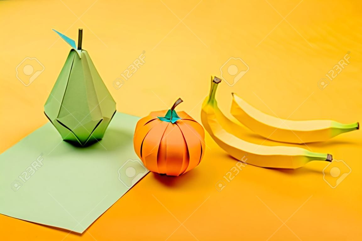 ręcznie robiona gruszka origami, banany i mandarynka na kolorowym papierze