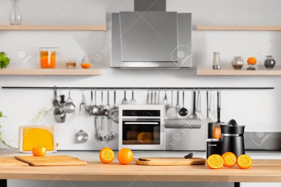 Moderne keuken met sappers, glas en lekkere biologische sinaasappels op houten tafel