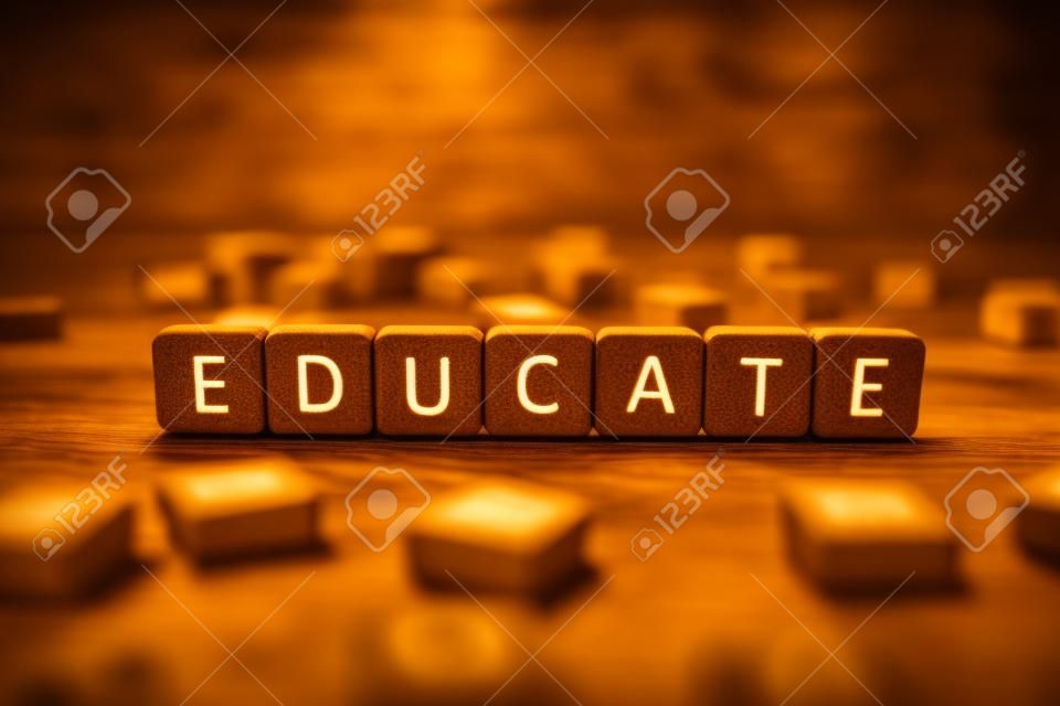 fuoco selettivo della parola educare fatta di cubi circondati da blocchi con lettere su una superficie di legno isolata su nero