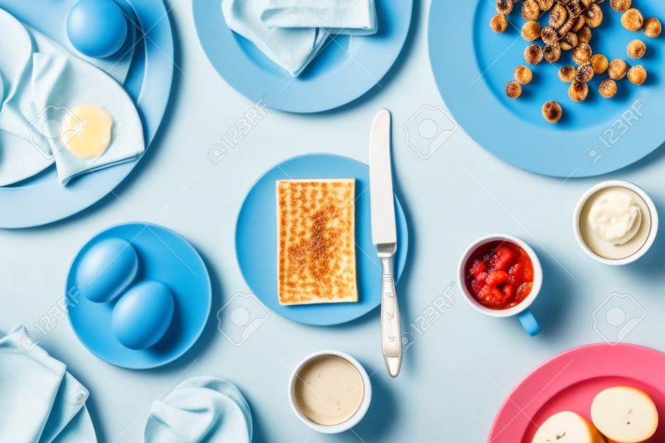 Top uitzicht op geserveerd ontbijt op blauwe achtergrond