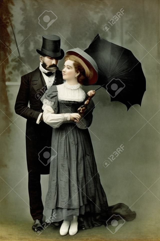 handsome victorian man standing with attractive woman holding umbrella