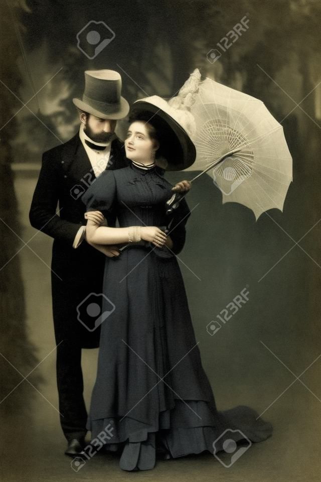 bell'uomo vittoriano in piedi con una donna attraente che tiene l'ombrello?