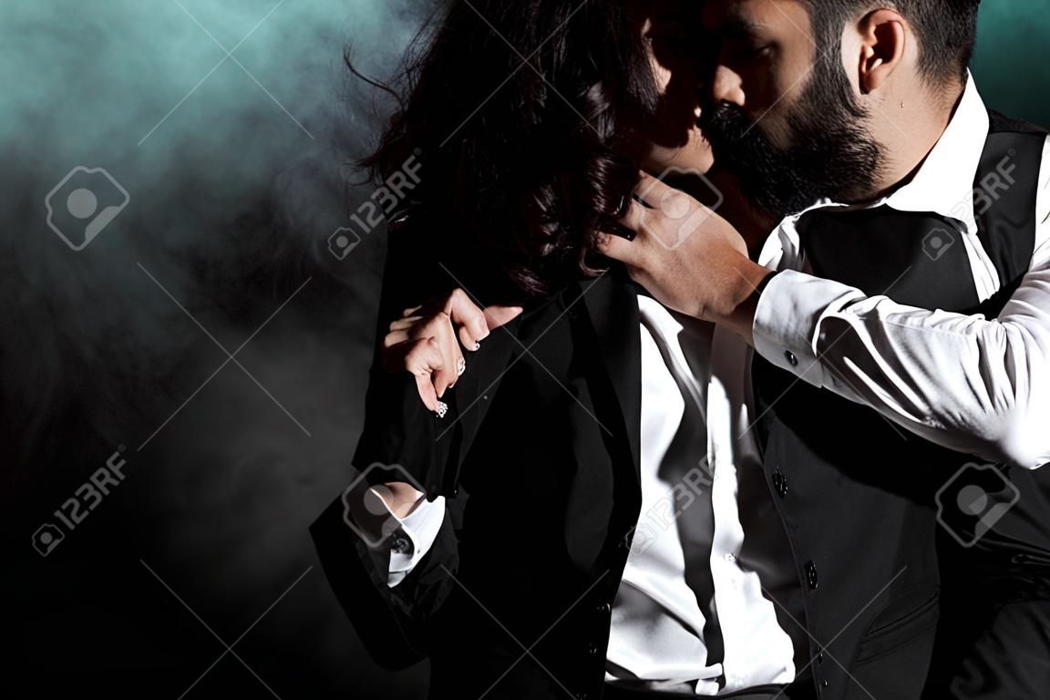 cropped view of woman standing and touching bearded man on black with smoke