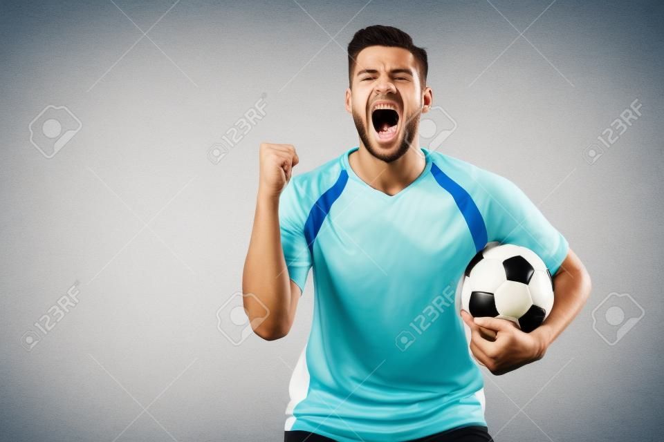 opgewonden voetballer met bal en gebalde hand schreeuwen geïsoleerd op wit