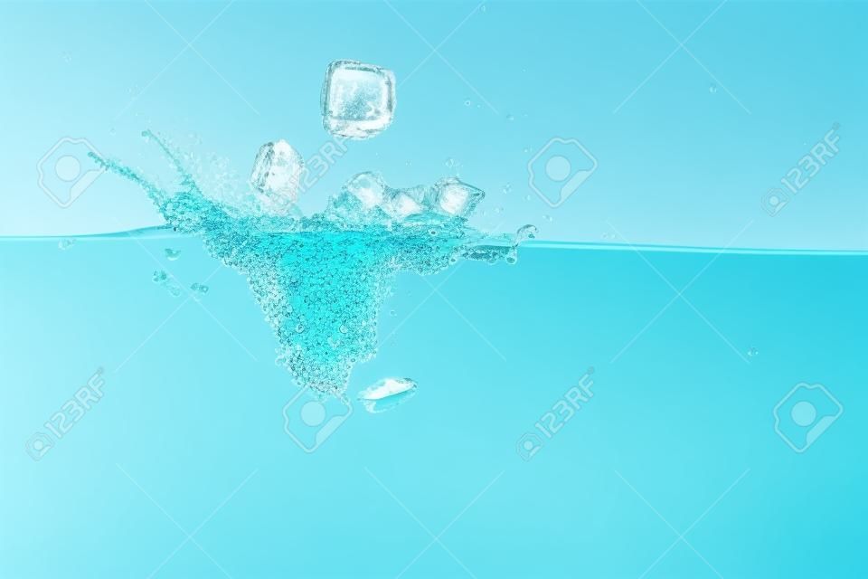 transparent ice cubes falling deep in clear water with splash on turquoise background