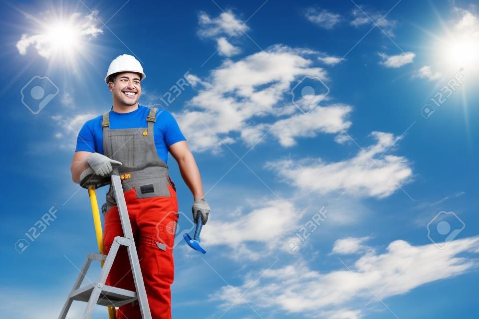 happy repairman standing on ladder and smiling against blue sky with clouds