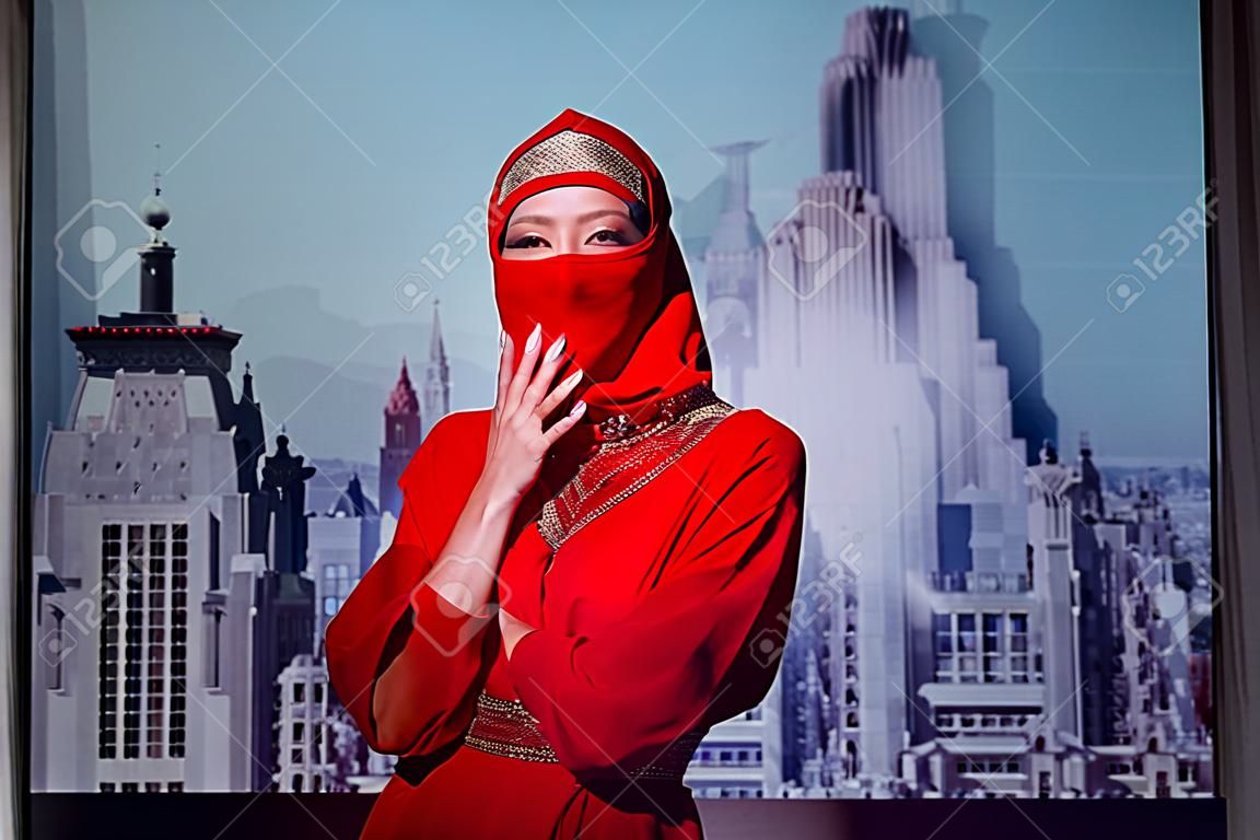 stylish woman in red dress and balaclava on city background