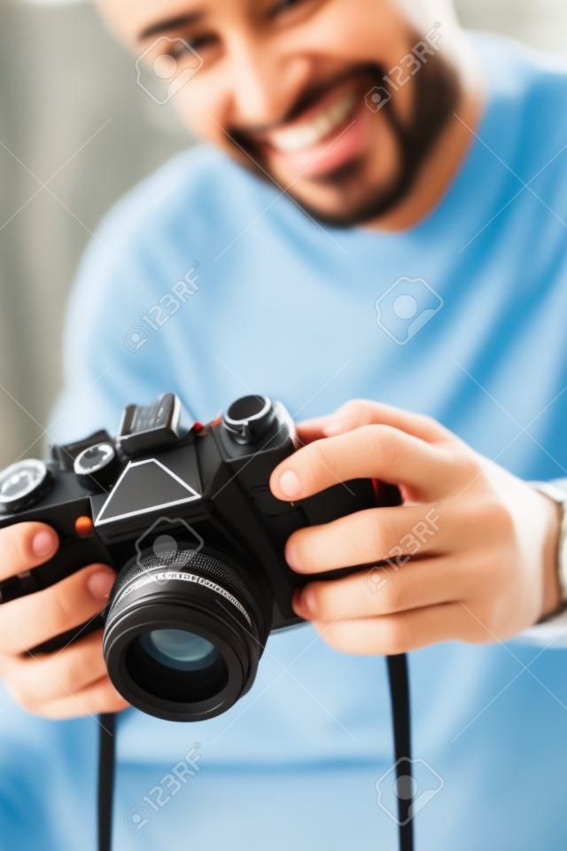 Selektiver Fokus eines lächelnden Mannes mit zwei Rassen, der eine Digitalkamera hält