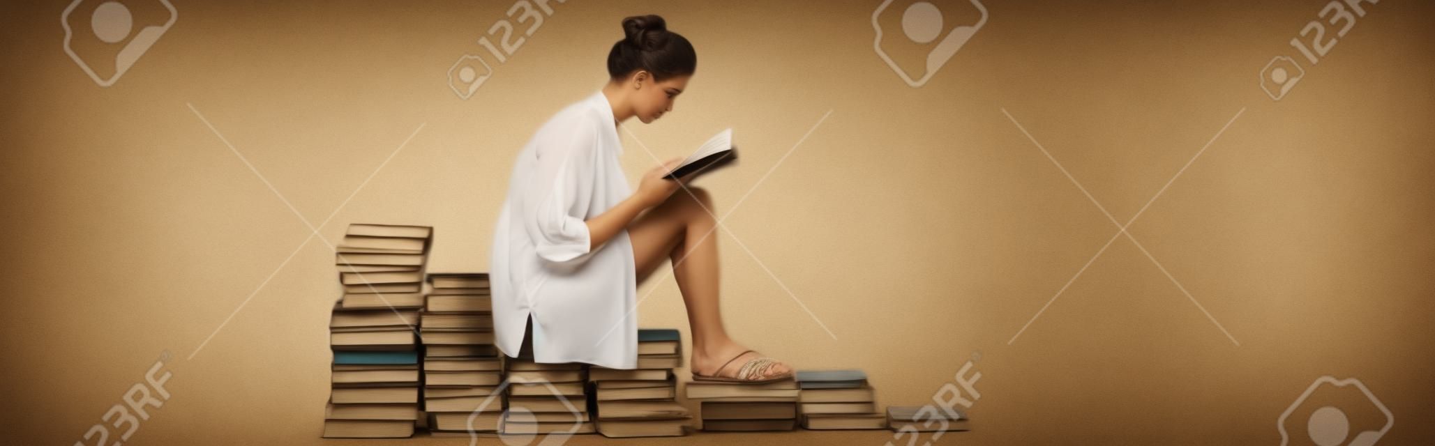 흰색, 배너에 책 더미에 앉아있는 동안 읽는 샌들에 젊은 여자의 측면 보기